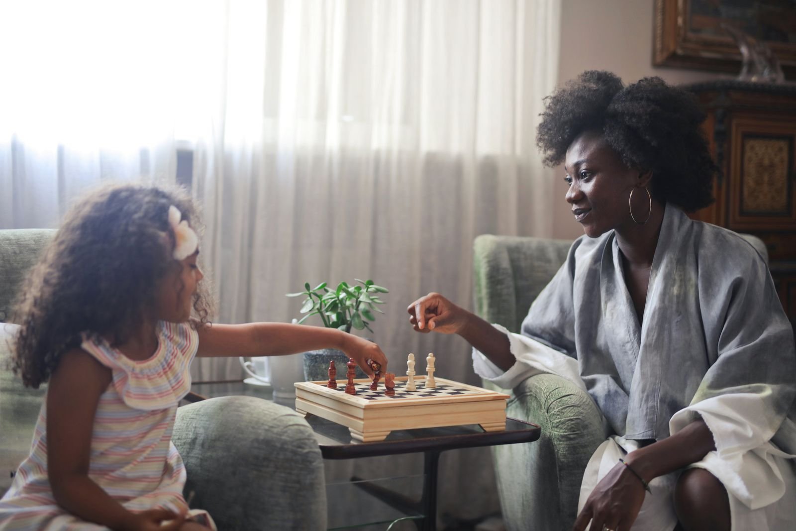 A mother and daughter playing chess together at home