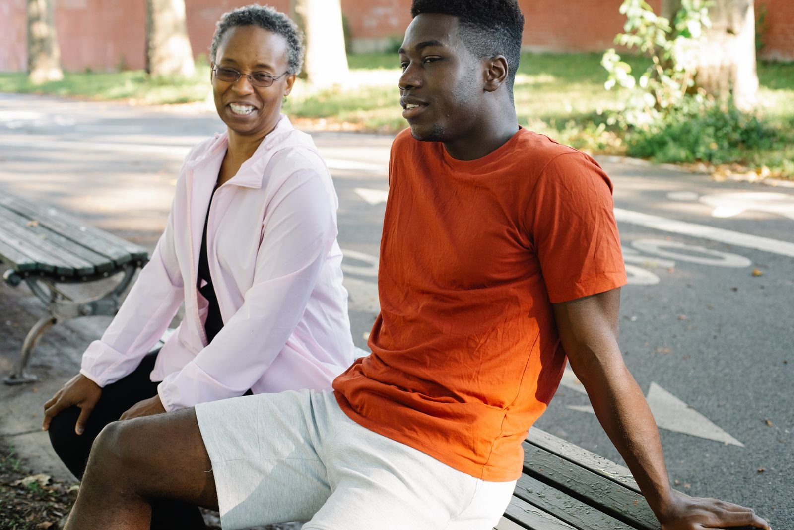 A mother and her adult son talking together on a park bench