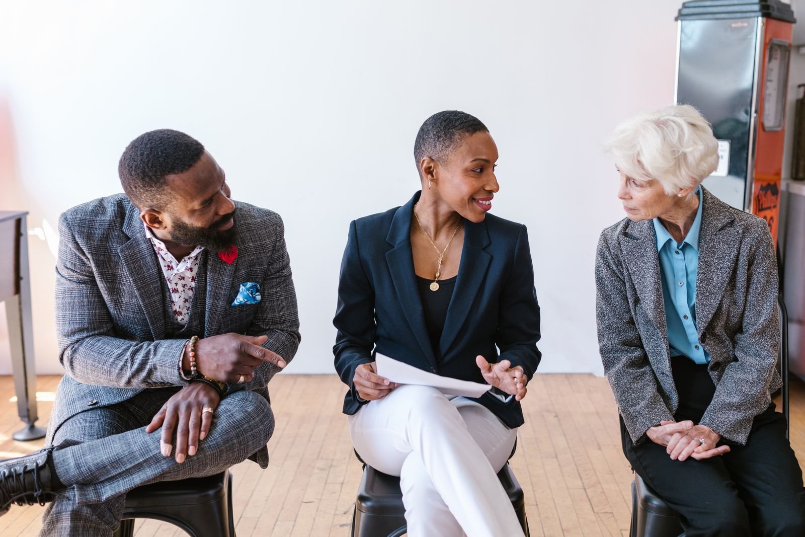 Three professionals in conversation during a community partnership meeting
