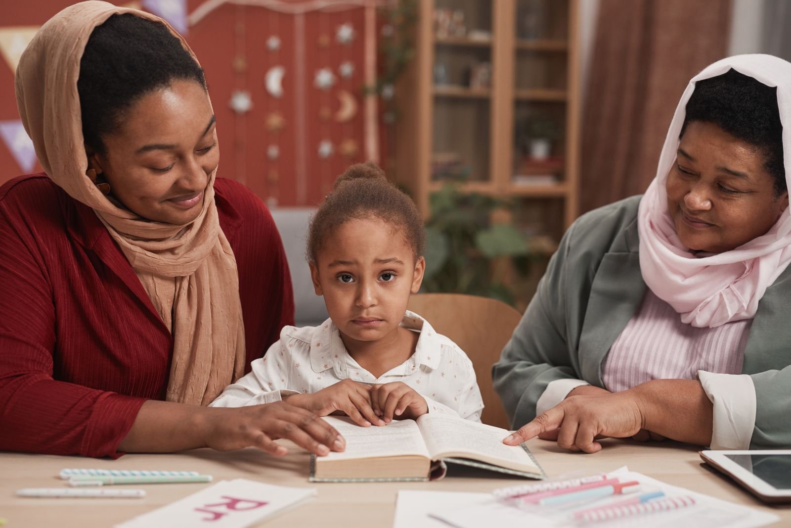 A grandmother, mother, and daughter reading together at a PCR Inc. family literacy circle
