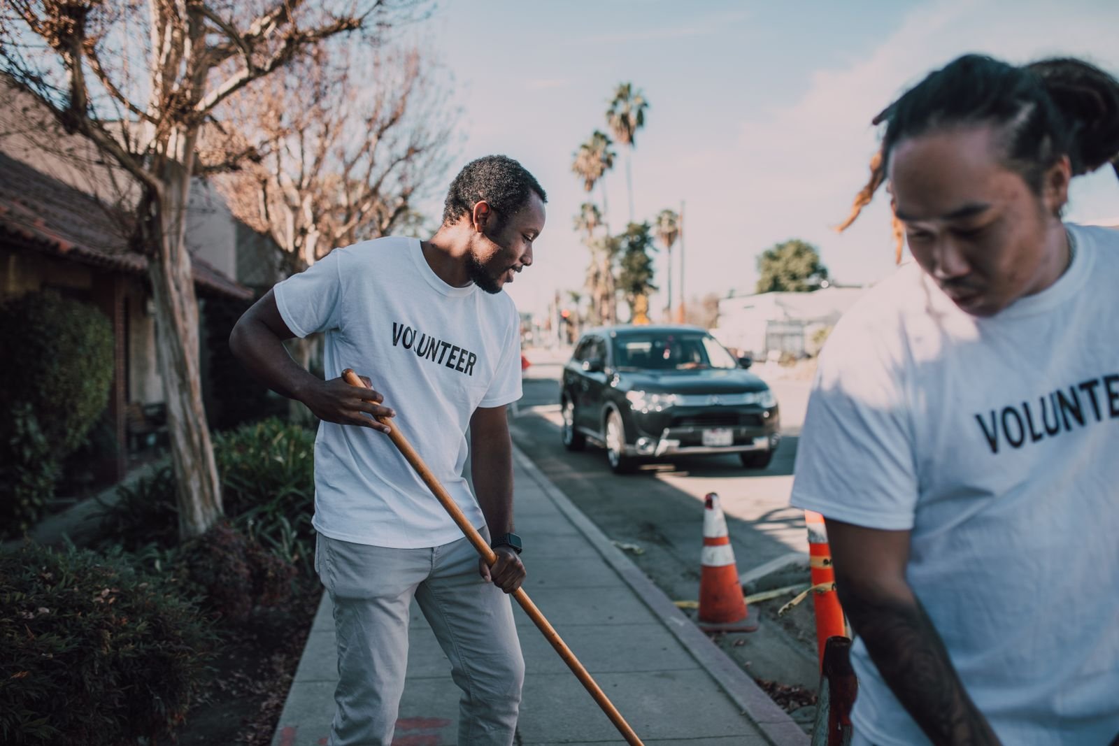 Volunteers cleaning a neighborhood sidewalk during a community service day