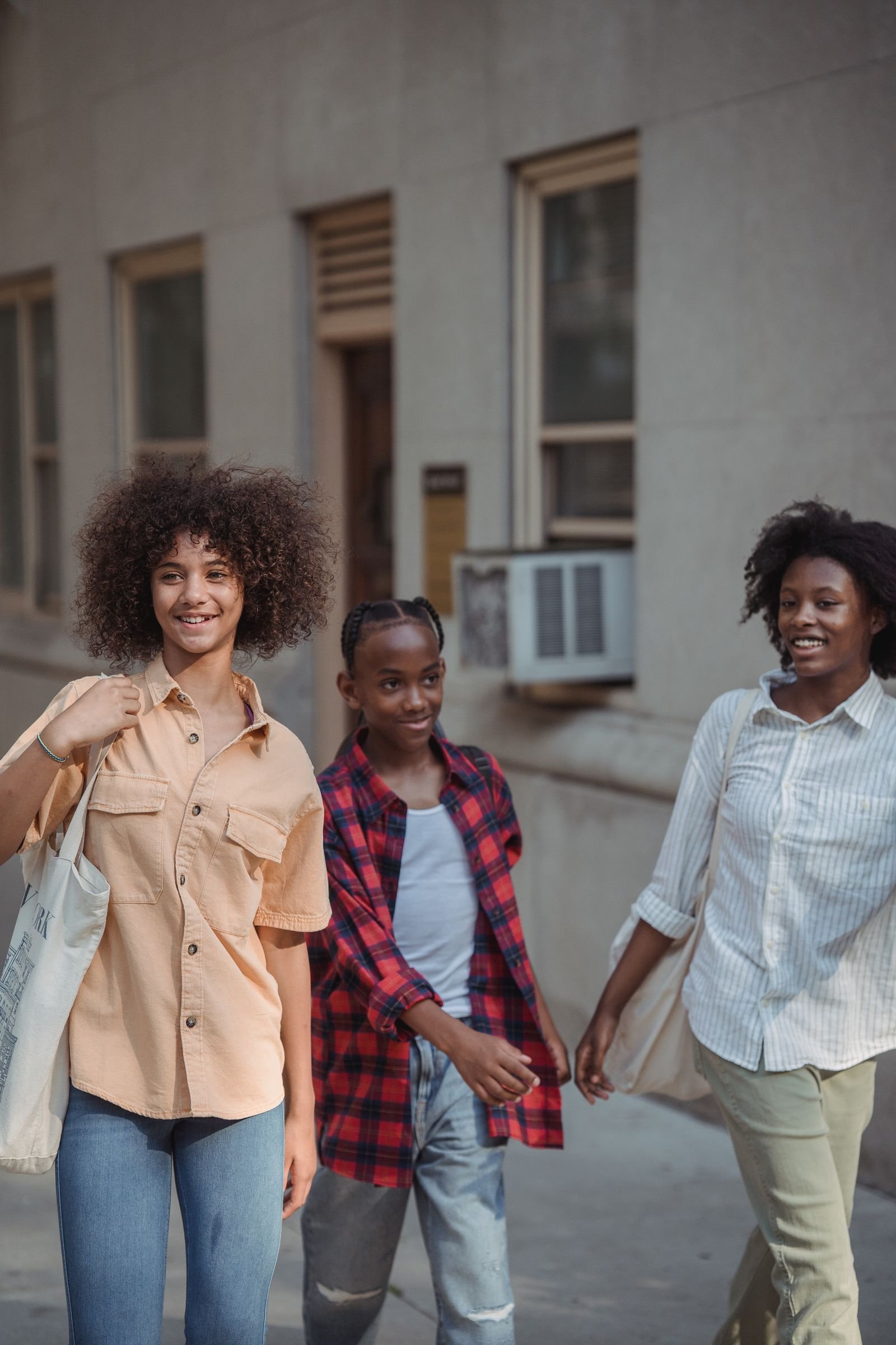 Three young people walking together through their Boston neighborhood